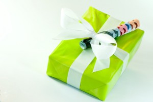 Grünes Geschenk mit weißer Schleife