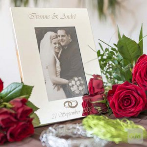 Hochzeitsrahmen mit Namen, Datum und Eheringen umgeben von Rosensträußen