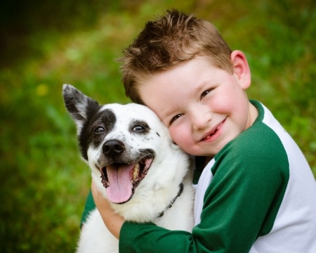 Kleines Kind mit einem Hund in den Armen