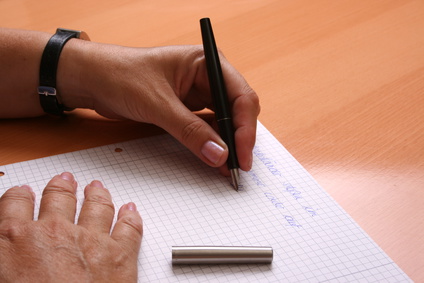Person schreibt auf Papier